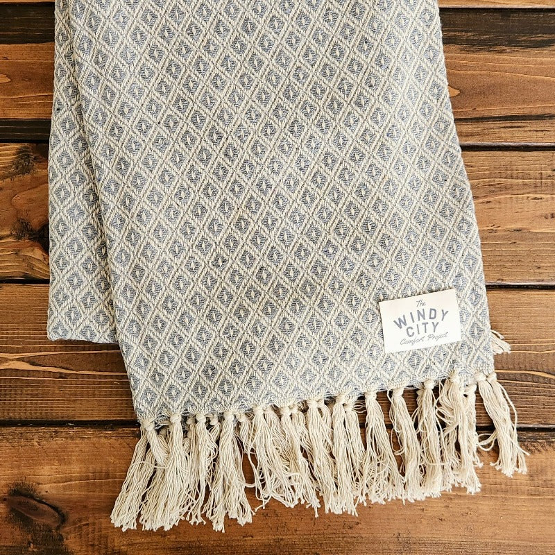 Simple and luxurious, the Comfort Classic blanket from India is handcrafted from 100% natural, environmentally friendly cotton, offering ultimate softness and plush comfort. Featuring a stylish diamond pattern, it provides an exquisite aesthetic that complements any décor. Its generous 70” x 50” size and lightweight design offer both comfort and convenience. 