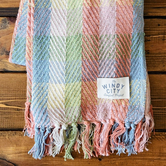 <strong>Our Hoppy Spring Throw is made from washed and recycled clothing, which is unraveled, cleaned, and re-woven!</strong> Artisans in India use jacquard looms to create a unique, recycled, medium-weight blanket. They are produced with approximately 60% cotton and 40% polyester blend materials and measure 60" x 50".