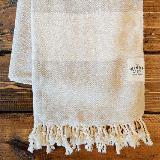 Summer Turkish Blanket - Stone-Our popular Turkish Blankets are back and even better this year! Now crafted by a family business in Turkey from 100% OEKO-TEX certified organic cotton, and slightly bigger at 72" x 38", this Turkish Towel is ready for all your spring and summer activities! Perfect to use as a blanket, shawl, wrap, scarf, throw, tablecloth, picnic blanket, bath towel... the options are endless! The tightly weaved cotton makes them sand-repellent and quick drying - the ideal blanket to take to 