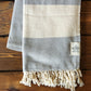 Our popular Turkish Blankets are back and even better this year! Now crafted by a family business in Turkey from 100% OEKO-TEX certified organic cotton, and slightly bigger at 72" x 38", this Turkish Towel is ready for all your spring and summer activities! Perfect to use as a blanket, shawl, wrap, scarf, throw, tablecloth, picnic blanket, bath towel... the options are endless! The tightly weaved cotton makes them sand-repellent and quick drying