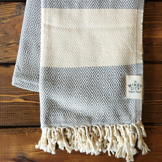 Our popular Turkish Blankets are back and even better this year! Now crafted by a family business in Turkey from 100% OEKO-TEX certified organic cotton, and slightly bigger at 72" x 38", this Turkish Towel is ready for all your spring and summer activities! Perfect to use as a blanket, shawl, wrap, scarf, throw, tablecloth, picnic blanket, bath towel... the options are endless! The tightly weaved cotton makes them sand-repellent and quick drying