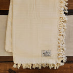 Our luxurious, solid cream-colored throw blanket brings a simple air of sophistication to any living space.