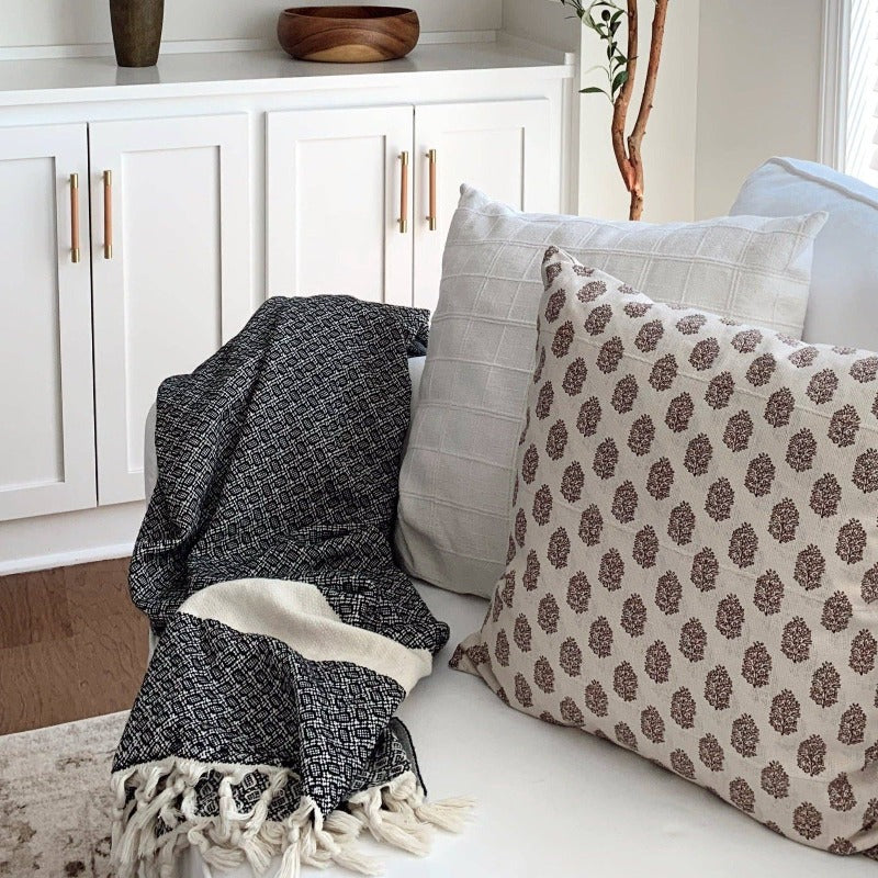 These Turkish throws have a stylish complex weave and are suited to use indoors and outdoors The incredibly soft hand-feel of these throws is truly luxurious! They are woven in a reversible black pattern and have a creme border complementing creme, and hand-spun tassels on the top and bottom edges. Large Throw: 55 inches X 78 inches 100% Turkish cotton